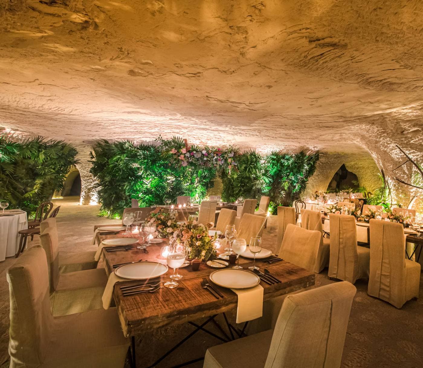 Reception tables set inside a warmly lit cave